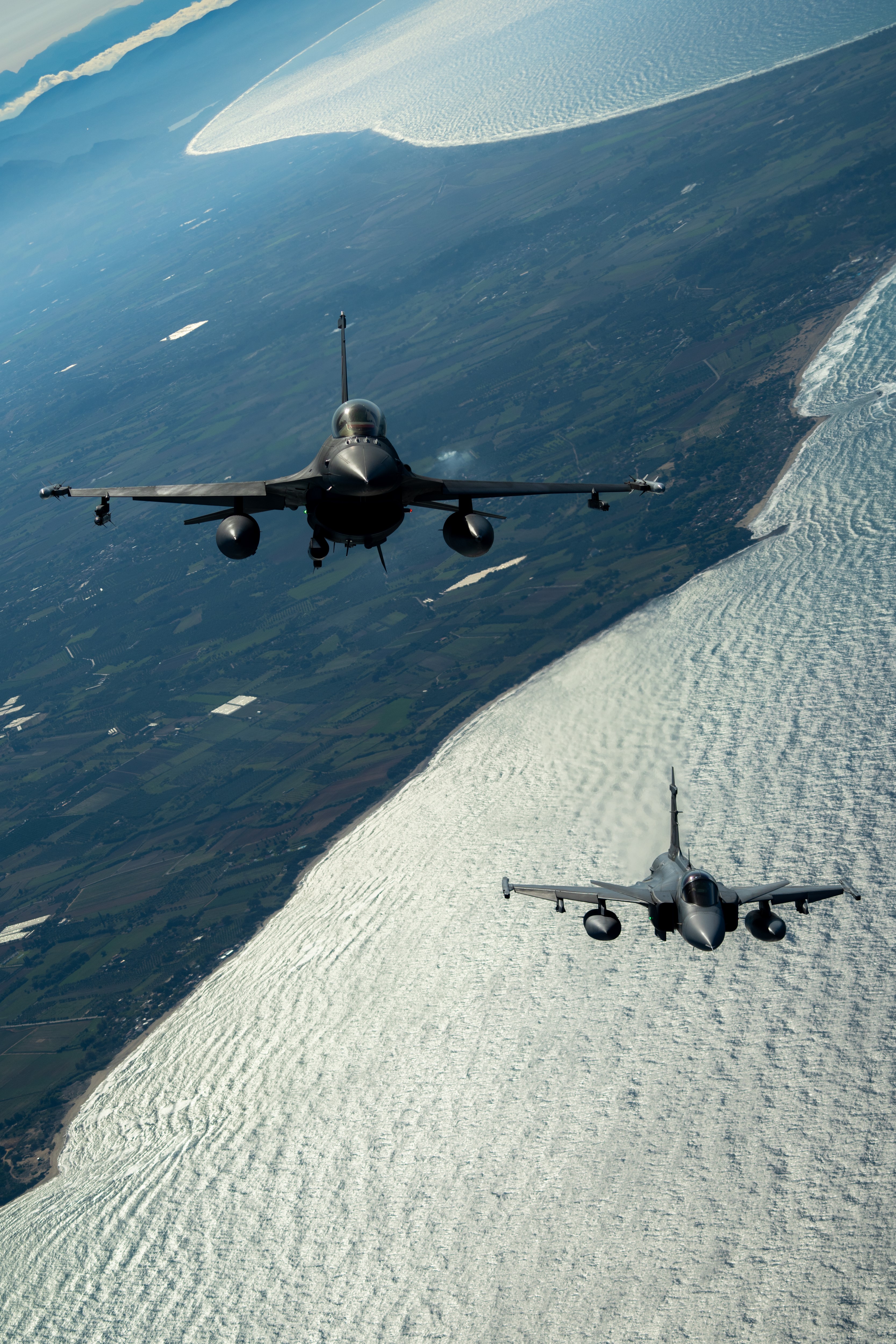 Polish Air Force F-16 and a Hungarian Air Force Gripen fly in formation during a training sortie over Greece